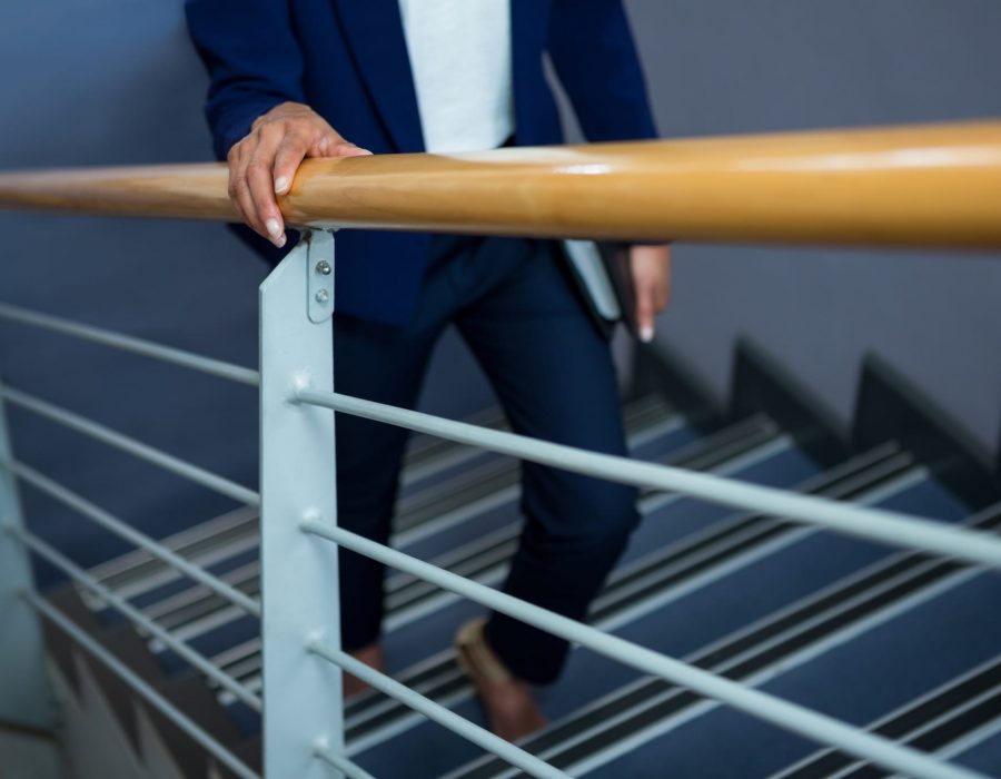 Businesswoman with diary climbing steps at conference centre