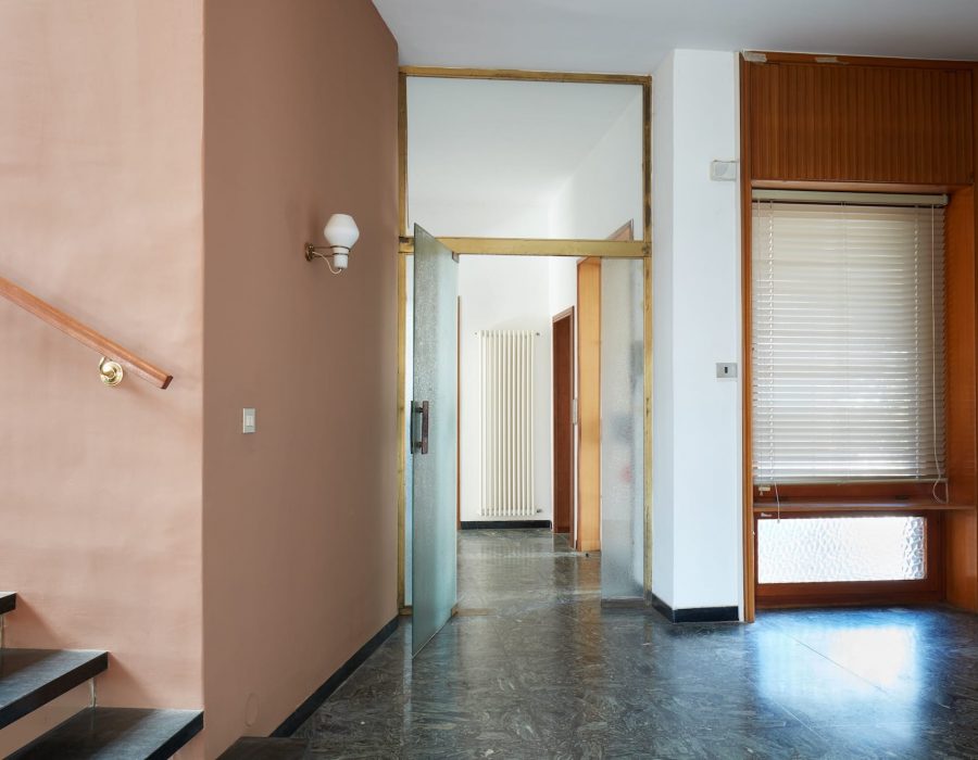 Entrance with black marble floor and glass door in apartment interior in old house